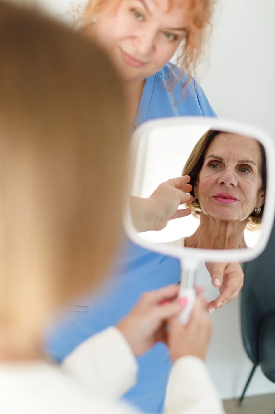 A client smiling at her reflection with Dr Tania, Cosmetic Medicine Birchington