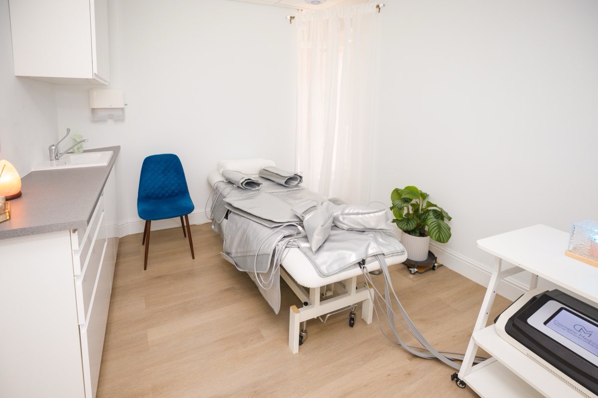 The pressotherapy treatment room at Cosmetic Medicine, with the suit on the bed and the machine beside it